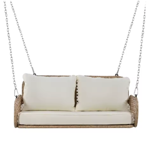 Fauteuil suspendu de jardin en résine tressée beige avec coussins blancs.