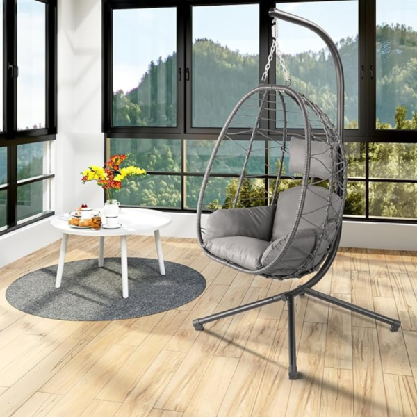 Fauteuil suspendu installé à l'intérieur face à une baie vitrée.