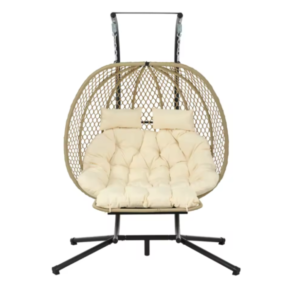 Fauteuil suspendu sur pied en résine tressée beige avec un grand coussin écru confortable pour deux personnes.