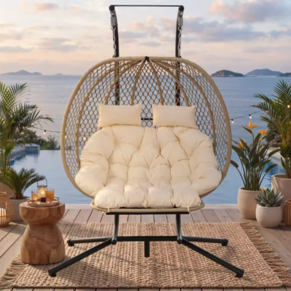 Fauteuil suspendu double placé sur une terrasse au bord d'une piscine avec une vue imprenable sur la mer.