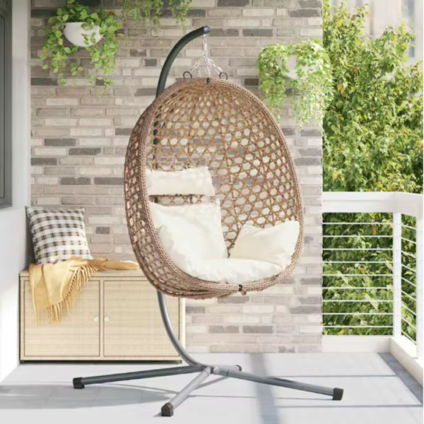 Fauteuil suspendu installé sur un balcon moderne avec plantes vertes.